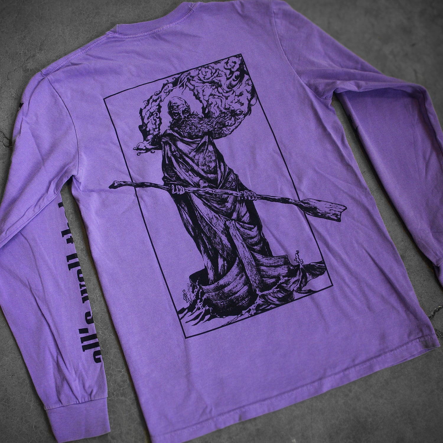 image of the back of a violet long sleeve tee shirt. there is a full print in black of bearded man in a cloak standing in a boat with an oar. 